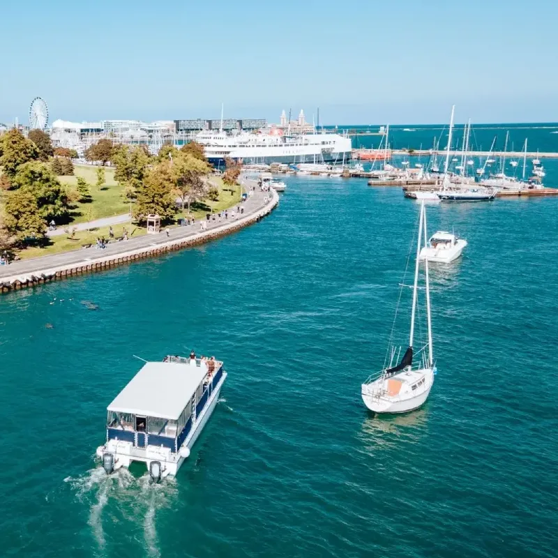 A big boat, sailboat, and yacht sailing into a marina on Lake Michigan in Chicago